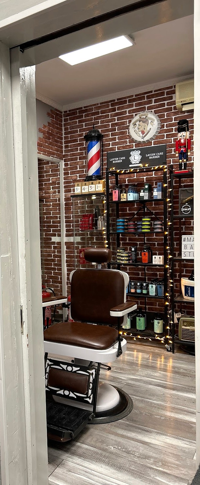 Το εσωτερικό του Marios Barber Studio, με τούβλο και δερμάτινη πολυθρόνα